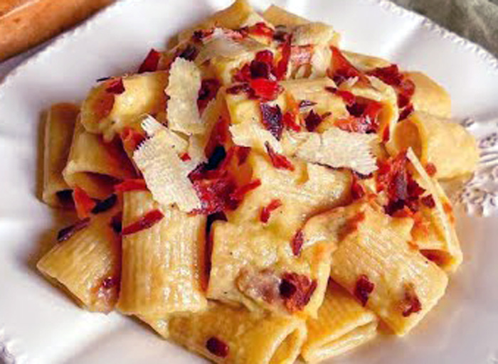 Preparazione della pasta con crema di porri e patate con speck croccante